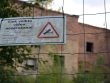 a sign is posted on a fence near a building