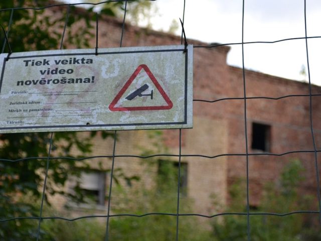 a sign is posted on a fence near a building